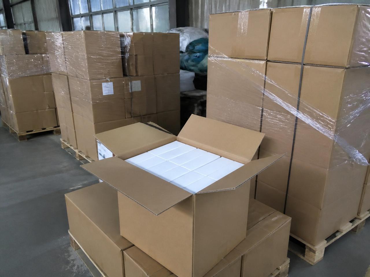 Cartons palettisés et contrôle du conditionnement avant expédition dans un entrepôt